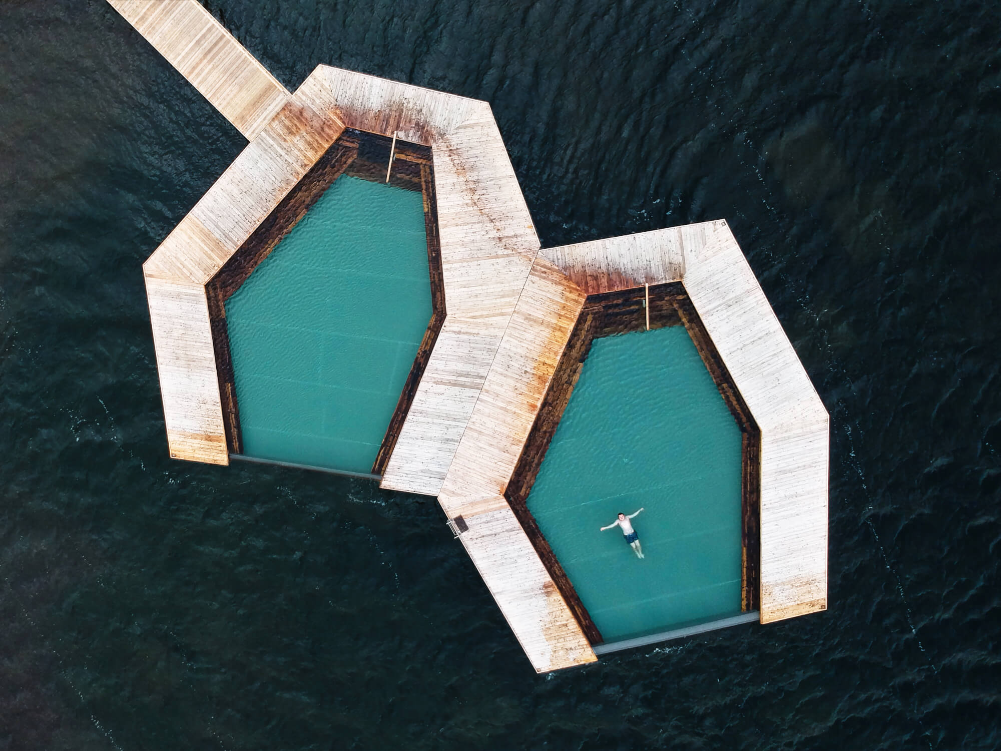 A person swimming in a floating pool at Vök Baths Thermal Spa, Iceland.